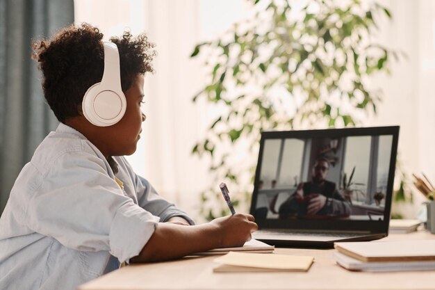 Junge, der Online-Unterricht mit Lehrer hat