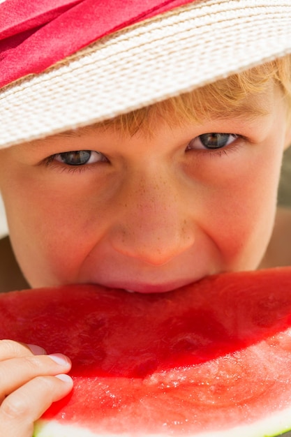 Junge, der rote reife Wassermelone isst Sommerferien und Urlaubskonzept