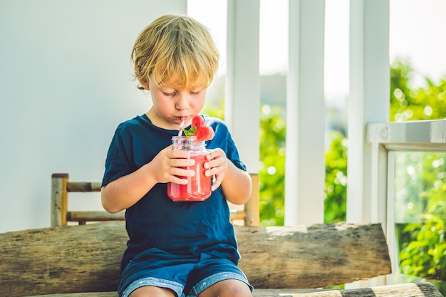 Junge, der saftigen Wassermelonen-Smoothie trinkt