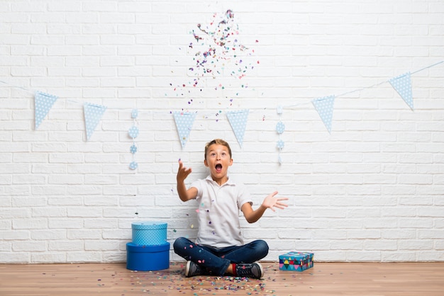 Junge, der seinen Geburtstag mit Konfetti in einer Party feiert