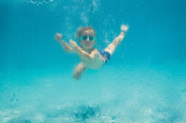 Junge, der Spaß hat, im Sommerurlaub unter Wasser im Schwimmbad zu spielen