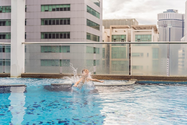 Junge, der zwischen den Wolkenkratzern und der Großstadt in den Pool springt, entspannen Sie sich in der Großstadt, um sich auszuruhen