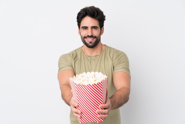 Junge, die eine große schüssel popcorn über lokalisierter wand halten