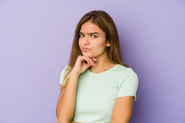 Junge dünne kaukasische Mädchen Teenager auf lila Hintergrund verdächtig, unsicher, Sie zu untersuchen.