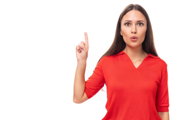 Junge, elegante, brünette Geschäftsfrau im roten T-Shirt auf weißem Hintergrund mit Kopierraum