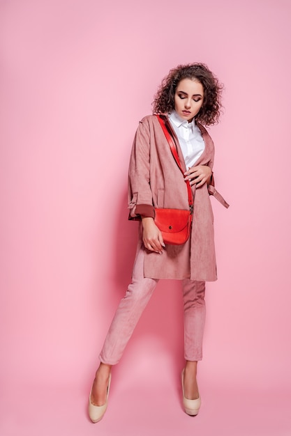 Junge elegante Frau in einem trendigen rosa Mantel