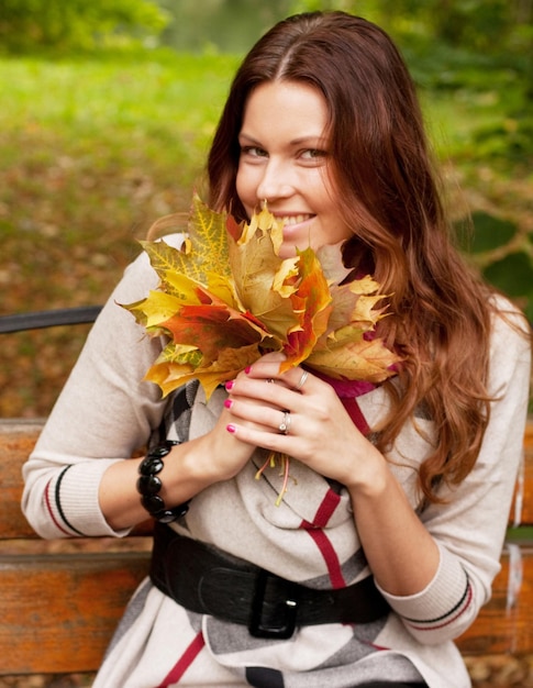 Foto junge elegante frau mit herbstlaub