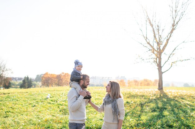 Junge Eltern mit ihrem Baby verbringen Zeit im Herbstpark.