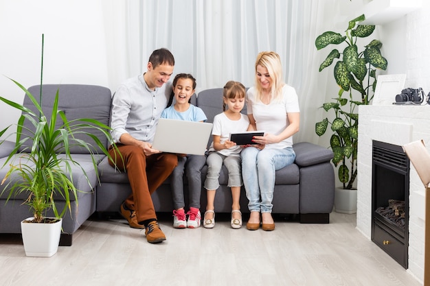 Junge Eltern mit Kindern auf Laptop-Computer