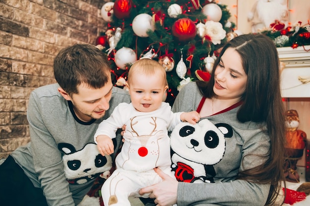 Junge Eltern mit kleinem Sohn nahe Weihnachtsbaum