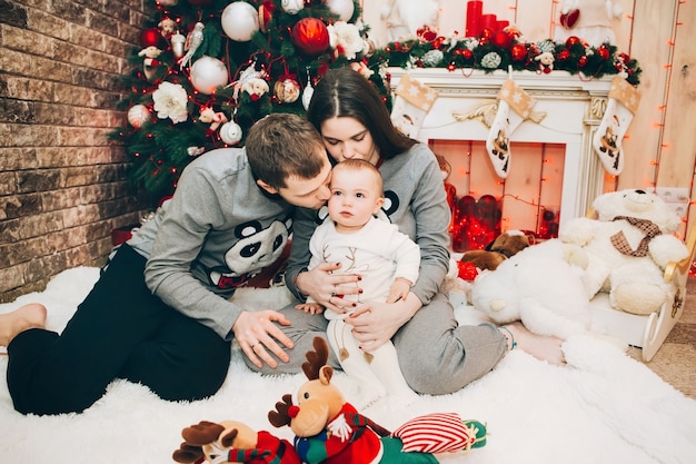 Junge Eltern mit kleinem Sohn nahe Weihnachtsbaum