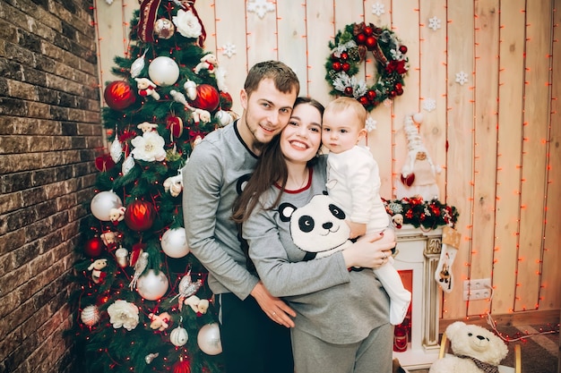 Junge Eltern mit kleinem Sohn nahe Weihnachtsbaum