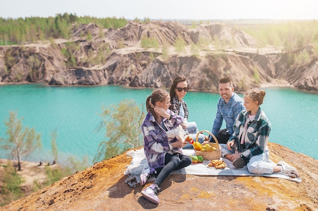 Junge Eltern und Kinder beim Picknick nach dem Wandern in den Bergen Schöne Aussicht auf den blauen See