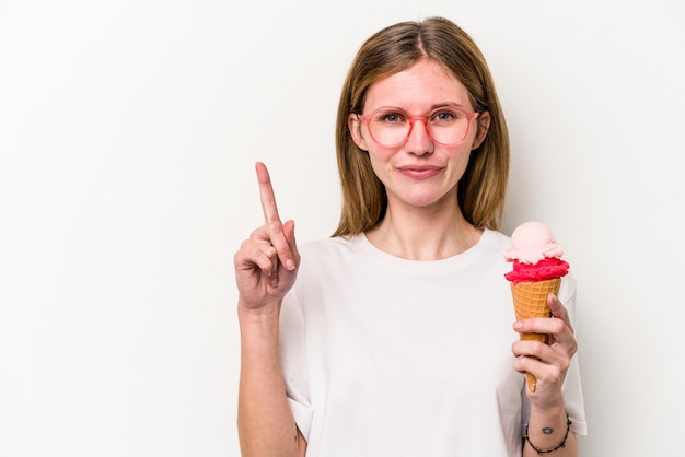 Junge Engländerin, die ein Eis isoliert auf weißem Hintergrund hält und die Nummer eins mit dem Finger zeigt