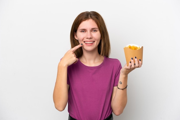 Junge Engländerin hält gebratene Chips isoliert auf weißem Hintergrund und gibt eine Daumen hoch Geste