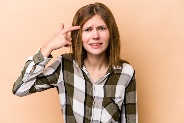 Foto junge engländerin isoliert auf beigem hintergrund, die eine enttäuschungsgeste mit dem zeigefinger zeigt