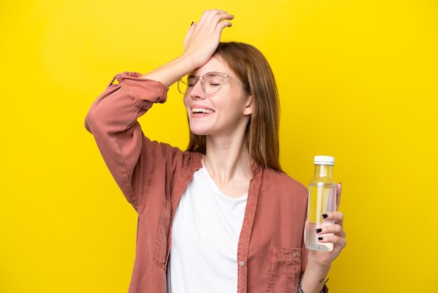 Junge Engländerin mit einer Flasche Wasser isoliert auf gelbem Hintergrund hat etwas erkannt und beabsichtigt die Lösung