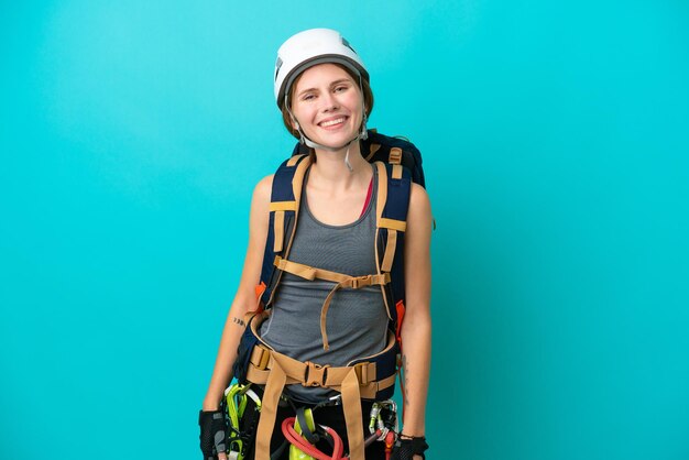 Junge englische Klettererfrau lokalisiert auf blauem Hintergrundlachen