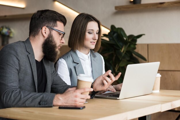 Junge erfolgreiche Geschäftspartner, die sich im Café unterhalten