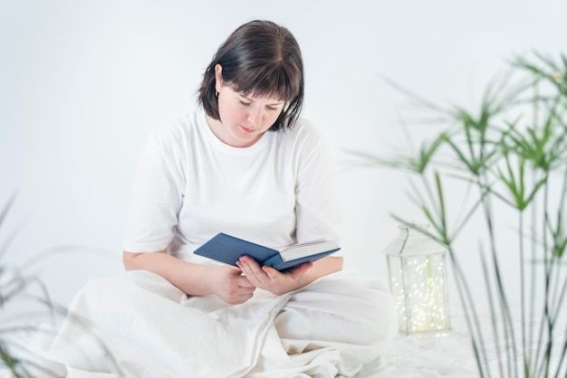 Junge erleuchtete Frau liest die Bibel. Mädchen liest das Buch begeistert und neigt den Kopf.