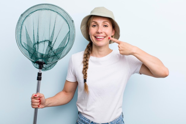 Junge erwachsene blonde Fischerfrau mit einem Nettourlaubs- und -hobbykonzept