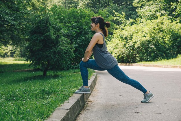 Junge erwachsene Frau, die durch den Stadtpark läuft, mit gesundem Lifestyle-Konzept der Musik