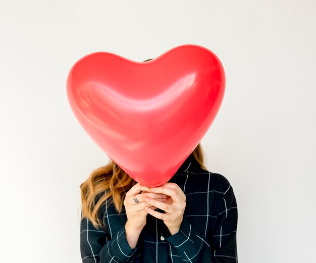 Junge erwachsene Frauen-Hände, die Herz-Ballon halten