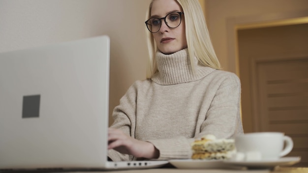 Junge erwachsene Geschäftsfrau, die auf Laptop-Computer tippt, der im Internet arbeitet, schöne weibliche professionelle Benutzerin, die PC-Technologie verwendet, die Online-Arbeit im Büro oder beim Surfen im Internet zu Hause Tisch macht