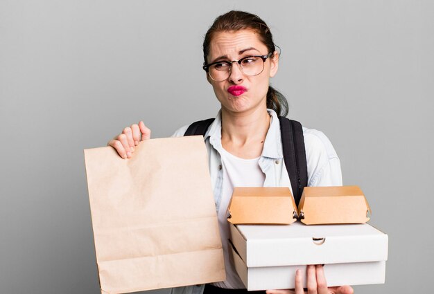 Junge erwachsene hübsche Frau mit Fast-Food-Boxen zum Mitnehmen