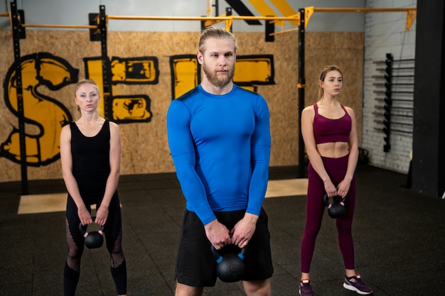 Foto junge erwachsene im sportstudio mit kettlebells