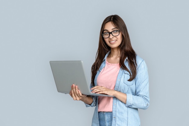 Junge erwachsene indische Frau mit modernem Laptop in den Händen