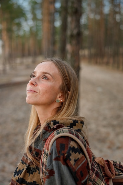 Junge ethnische reife schamanin geht und spielt schlagzeug meditative musik