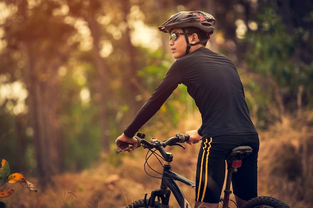 Junge fährt Fahrrad im Sonnenaufganglicht genießen Sie die Ansicht über Wiese