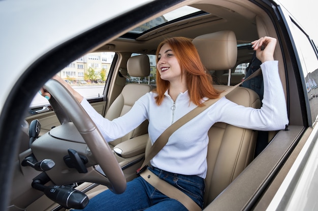 Junge Fahrerin durch Sicherheitsgurt beim Autofahren befestigt