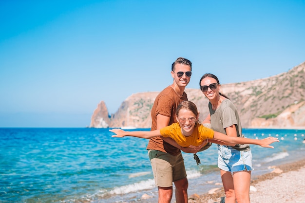 Junge Familie am weißen Strand während der Sommerferien