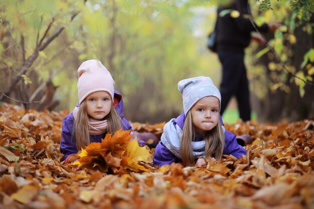 Junge Familie bei einem Spaziergang im Herbstpark an einem sonnigen Tag. Glück, zusammen zu sein.