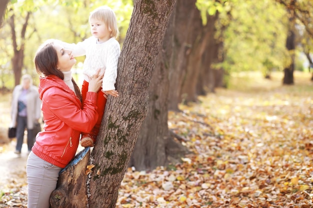 Junge Familie bei einem Spaziergang im Herbstpark an einem sonnigen Tag Glück, zusammen zu sein