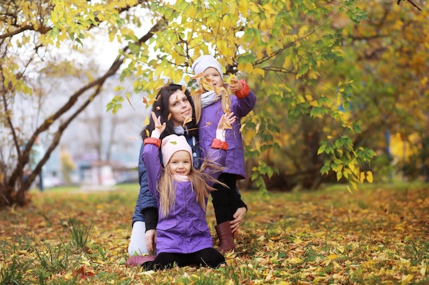 Junge Familie bei einem Spaziergang im Herbstpark an einem sonnigen Tag Glück, zusammen zu sein