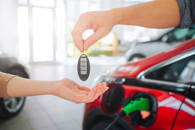 Junge Familie, die erstes Elektroauto im Ausstellungsraum kauft