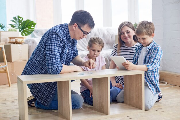 Junge Familie, die Garderobe zusammenbaut