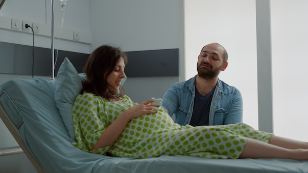 Junge Familie, die über die Geburt in der Krankenstation spricht