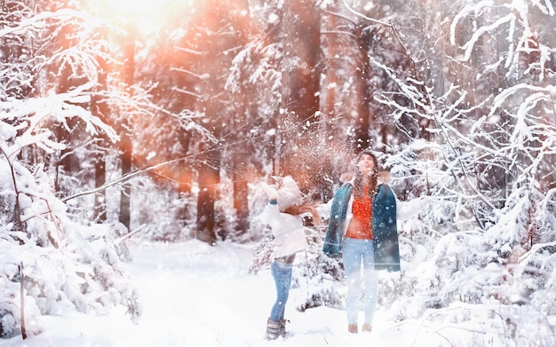 Junge Familie für einen Spaziergang. Mutter und Tochter gehen in einem Winterpark spazieren.