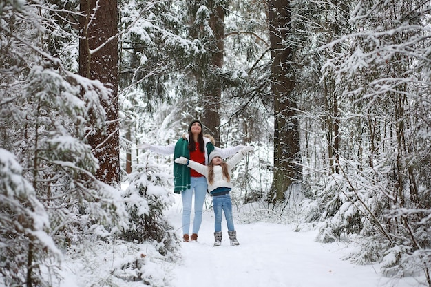 Junge Familie für einen Spaziergang. Mutter und Tochter gehen in einem Winterpark spazieren.