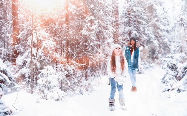 Junge Familie für einen Spaziergang. Mutter und Tochter gehen in einem Winterpark spazieren.