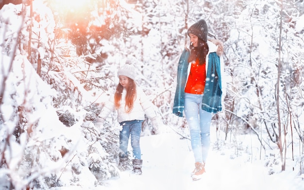 Junge Familie für einen Spaziergang. Mutter und Tochter gehen in einem Winterpark spazieren.