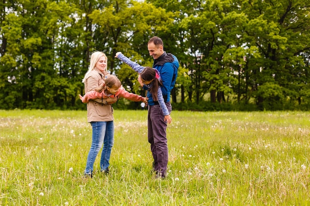 junge Familie geht durch eine grüne Wiese