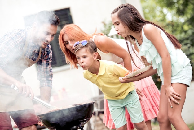 Foto junge familie grillt bei sich zu hause