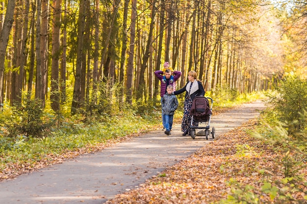 Junge Familie im Freien, die durch Herbst-Park geht