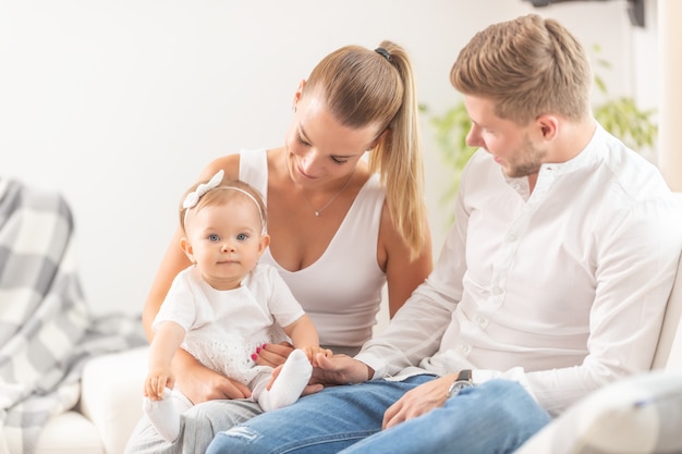 Junge Familie mit einem Baby, das im Haus spielt.