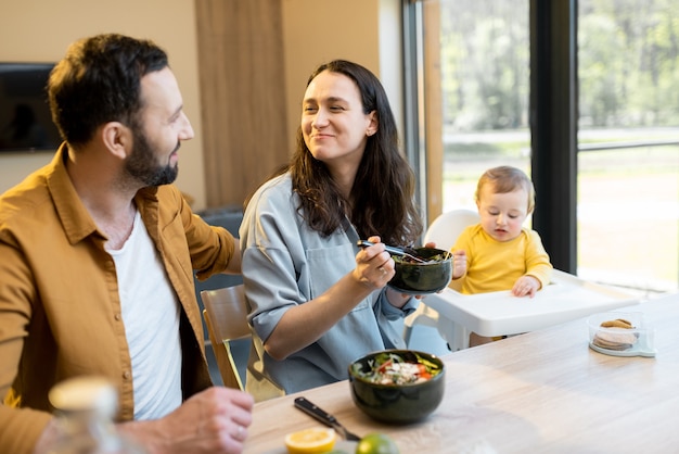 Junge Familie mit einem einjährigen Jungen während einer Mittagspause zu Hause